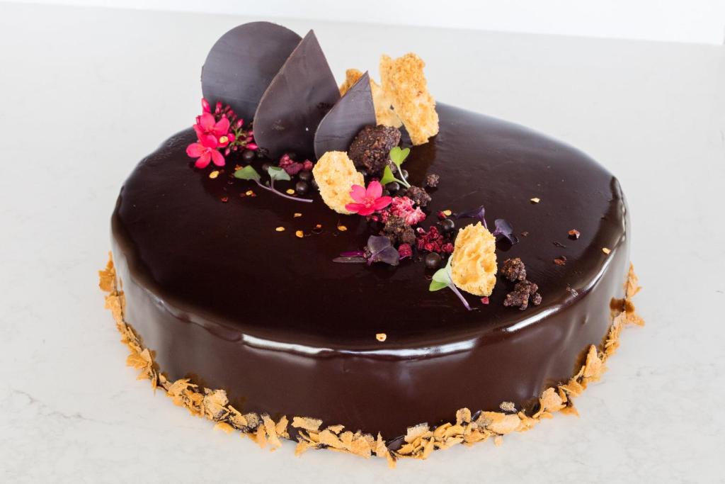a chocolate cake with flowers on top of it at Kimpton Seafire Resort + Spa by IHG in West Bay
