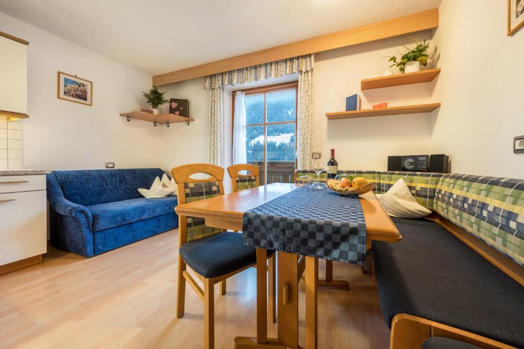 uma sala de estar com uma mesa e um sofá azul em Niederkoflhof Durreck em Cadipietra