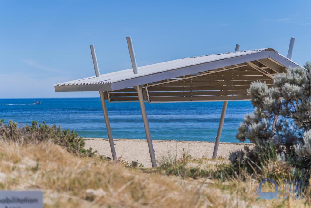 a shelter on the beach with the ocean in the background at Summer Breeze at Avalon Beach in Wannanup