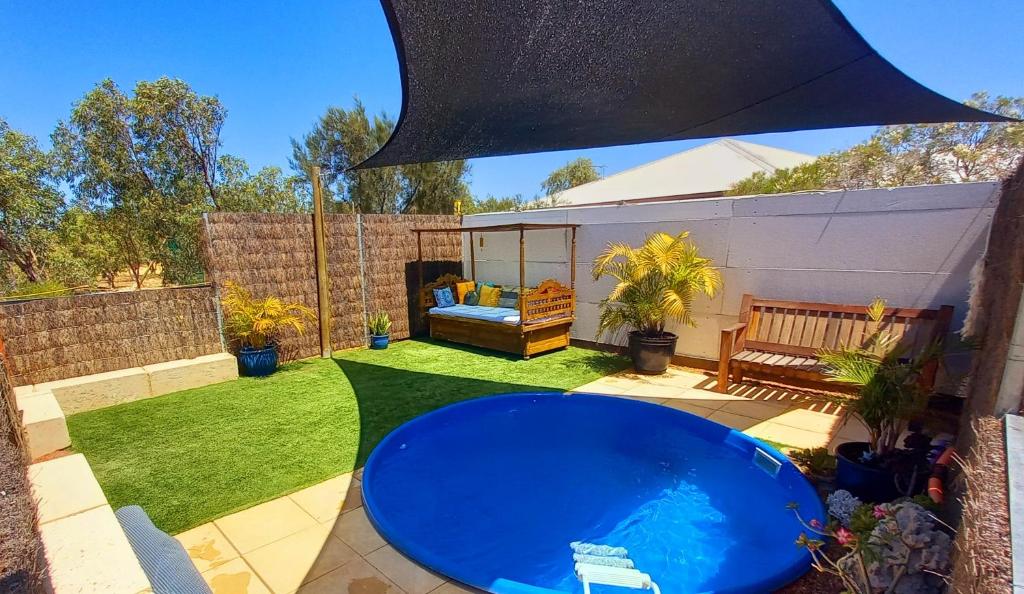 a patio with a blue table in a yard at Serenity in Style in Kalbarri