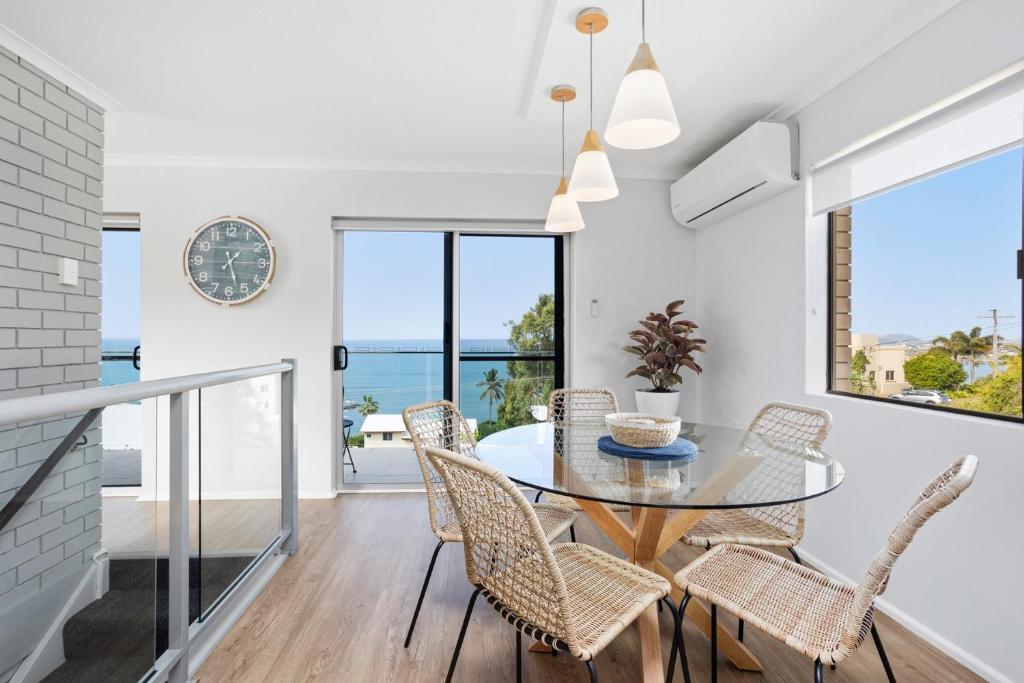 a dining room with a glass table and chairs at Freeman Retreat Yeppoon in Yeppoon