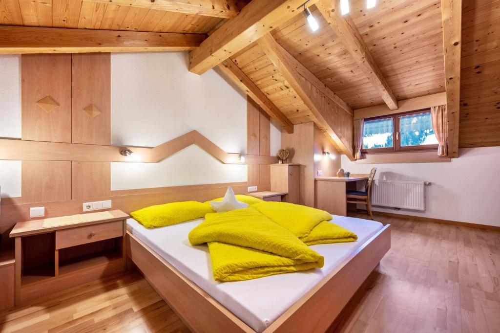 a bedroom with a large bed with yellow pillows at Niederkoflhof Wollbach in Cadipietra