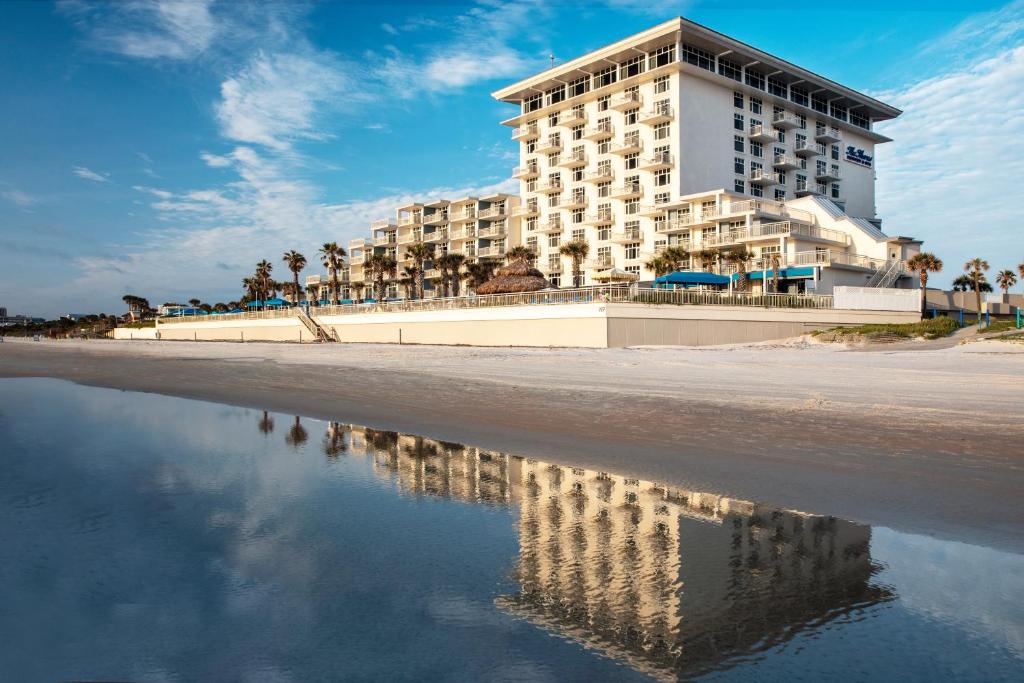 een hotel aan het strand met een reflectie in het water bij The Shores Resort & Spa in Daytona Beach