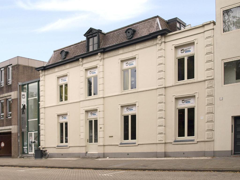 a large white building on a city street at 3BE Backpackers Bed & Breakfast Eindhoven in Eindhoven