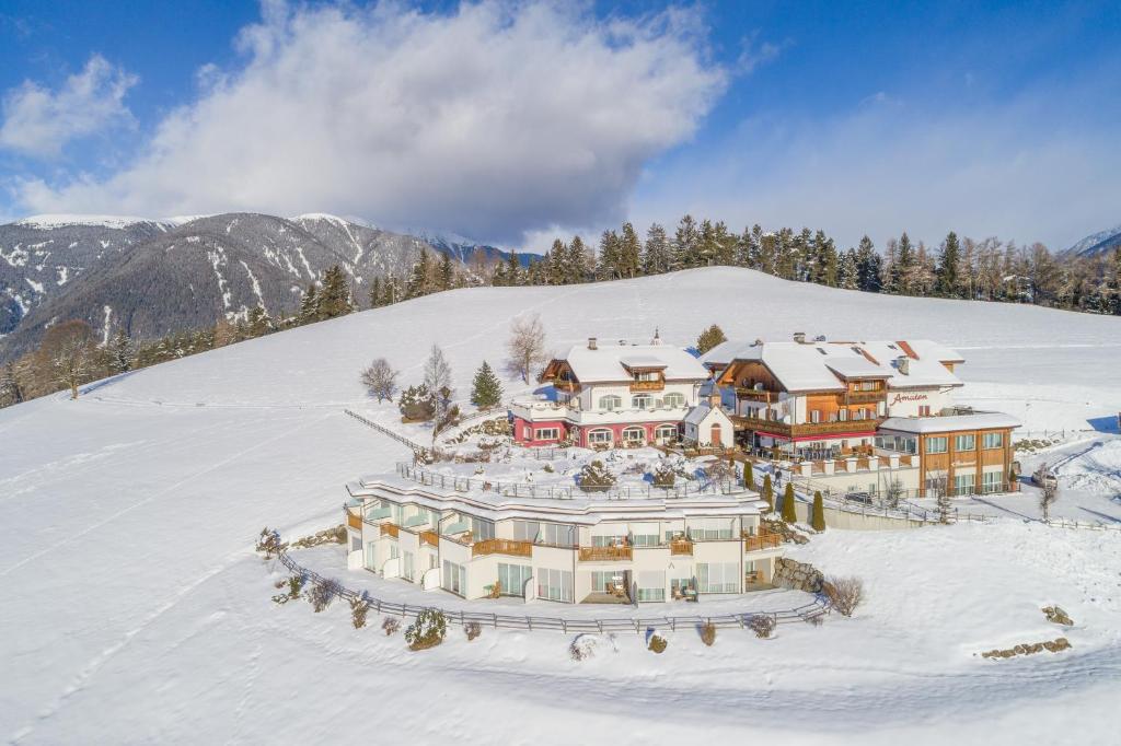 an aerial view of a resort in the snow at Hotel Amaten in Brunico