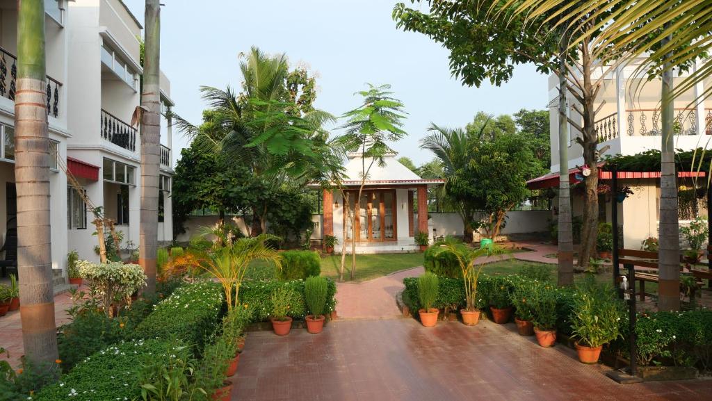 um pátio de um edifício com plantas e árvores em Upasana Eco Resort em Bolpur