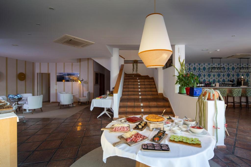 a table with food on it in a room with stairs at Boutique Hotel El Tio Kiko in Agua Amarga