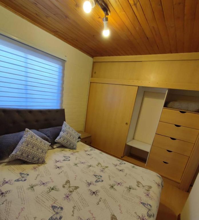 - une chambre avec un lit, une commode et une fenêtre dans l'établissement Vencido, à Chillán