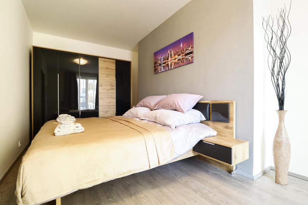 una camera da letto con un grande letto con cuscini rosa di Apartments / 10 min from center / O2 ARENA a Praga