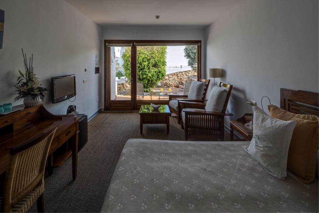 a living room with a bed and a couch and a television at Boutique Hotel El Tio Kiko in Agua Amarga