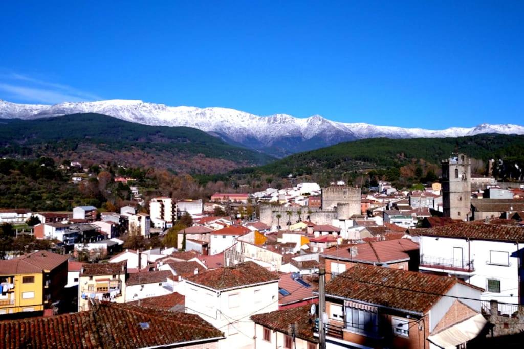 a city with snow covered mountains in the background at Casa Vaélico in Arenas de San Pedro
