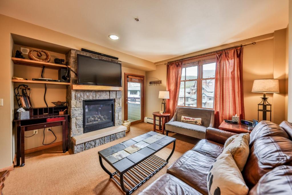 a living room with a couch and a fireplace at Zephyr Slopeside - 1504 condo in Winter Park