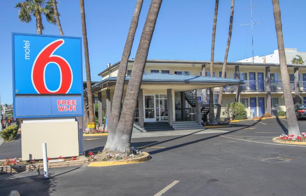 a sign in front of a hotel with palm trees at Motel 6 San Diego Airport/Harbor in San Diego