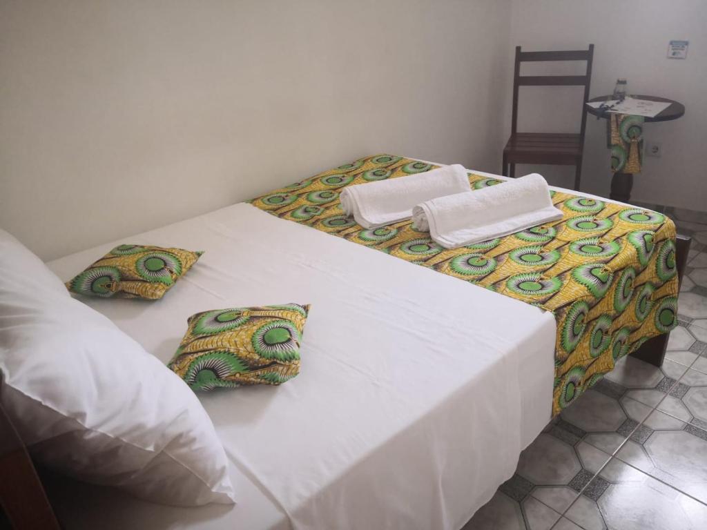 a bedroom with two beds with white sheets and pillows at Micaval Residential in São Tomé