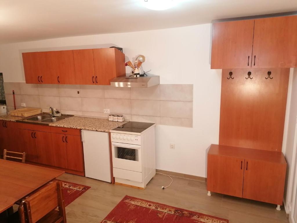 uma cozinha com armários de madeira e um forno de fogão branco em SIMIĆ planinska kuća em Divčibare