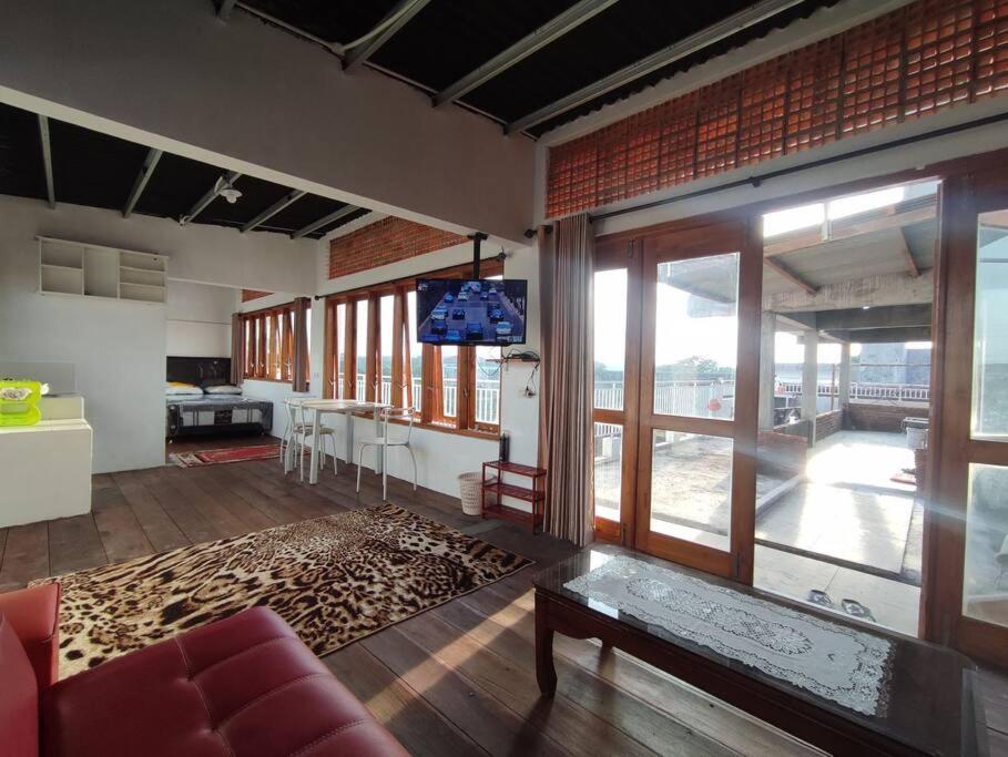 - un salon avec un canapé rouge et une grande fenêtre dans l'établissement Kost or Pasutri Rooftop Pogung Dalangan Sleman, à Kejayan