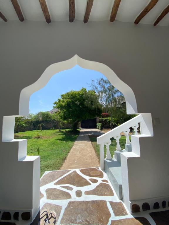 an archway leading up to a house with a garden at Mumbi villa in Watamu