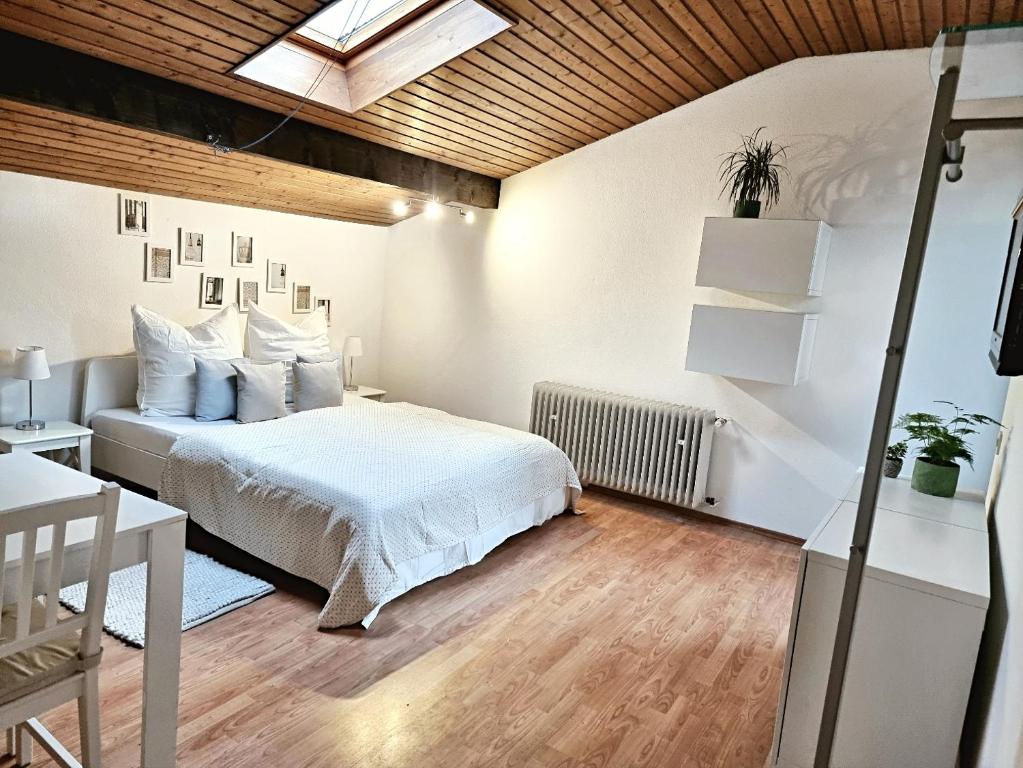 - une chambre avec un lit blanc et un plafond en bois dans l'établissement Birnie, à Wiesbaden