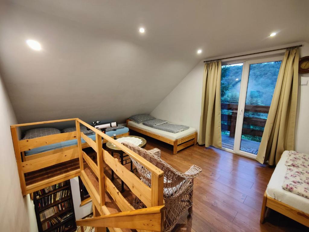 a room with two bunk beds and a balcony at Chatka Pod Trohańcem in Lutowiska