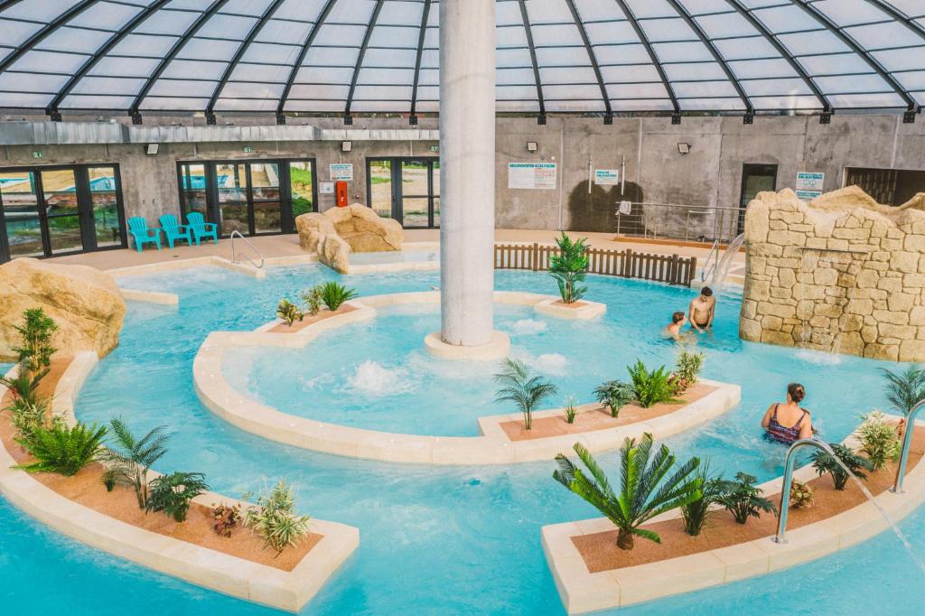 a pool in a building with a water park at Camping Les Garennes in Rang-du-Fliers