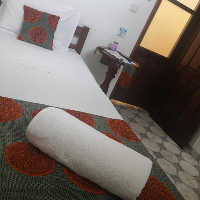 a bedroom with a bed with a white blanket on it at Micaval Residential in São Tomé