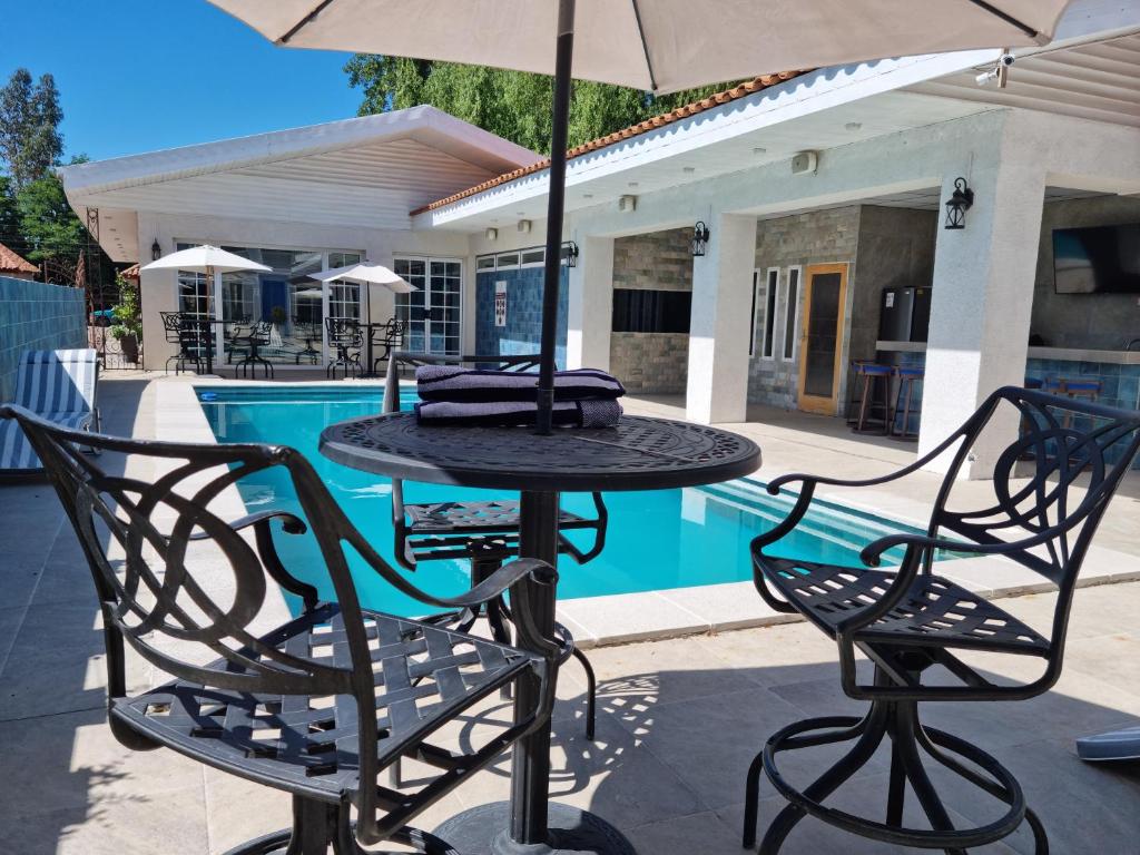 a table and chairs with an umbrella next to a pool at Hotel Boutique Grand Cru in Santa Cruz