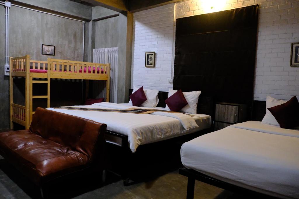 um quarto com duas camas e um sofá em BAAN9NAN Home Lodge em Nan