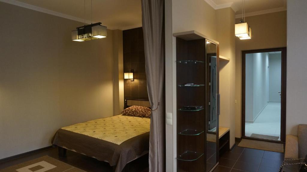 a small bedroom with a bed and a mirror at Main Street Apartments in Chişinău