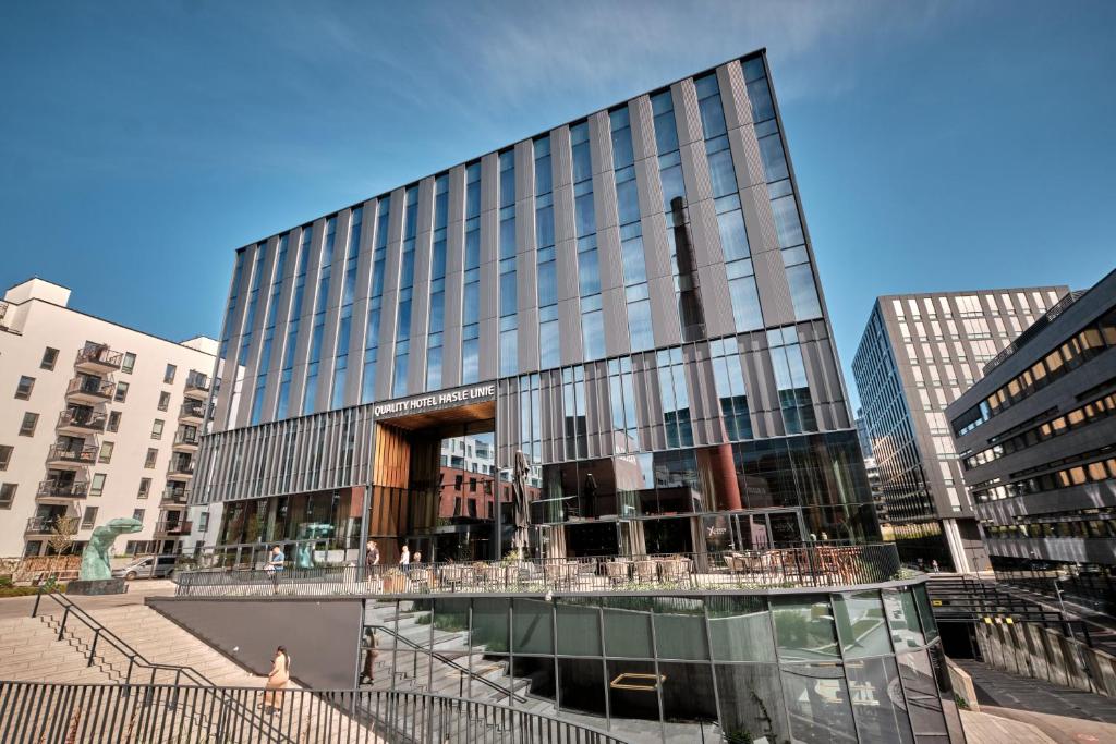 ein hohes Glasgebäude mit einer Treppe davor in der Unterkunft Quality Hotel Hasle Linie in Oslo