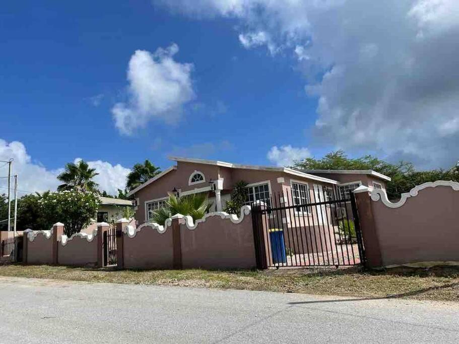 a house with a fence in front of it at Beautiful house in Sabana Basora Aruba! in Savaneta