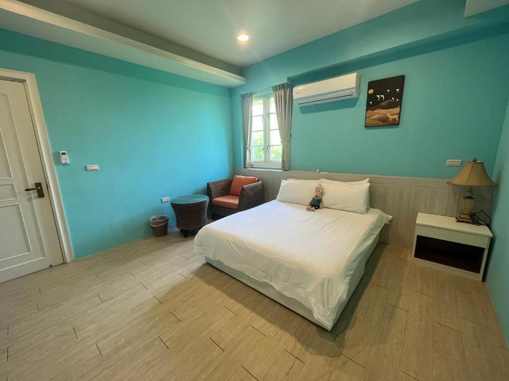 a bedroom with blue walls and a bed and a chair at 伊莎愛莉溜滑梯親子民宿 in Wujie