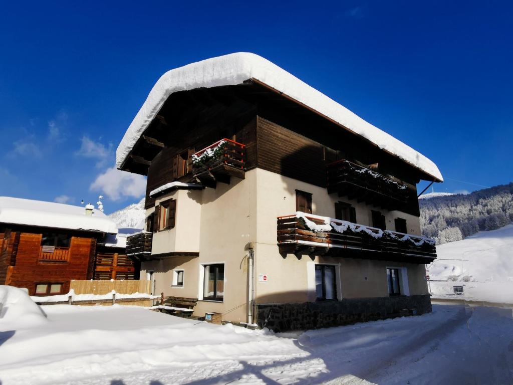 un bâtiment recouvert de neige sur le toit dans l'établissement Livigno Elisir Petit, à Livigno