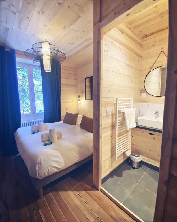 a bedroom with a bed in a wooden cabin at Hôtel Restaurant "La Petite Auberge" in Bourg-Saint-Maurice