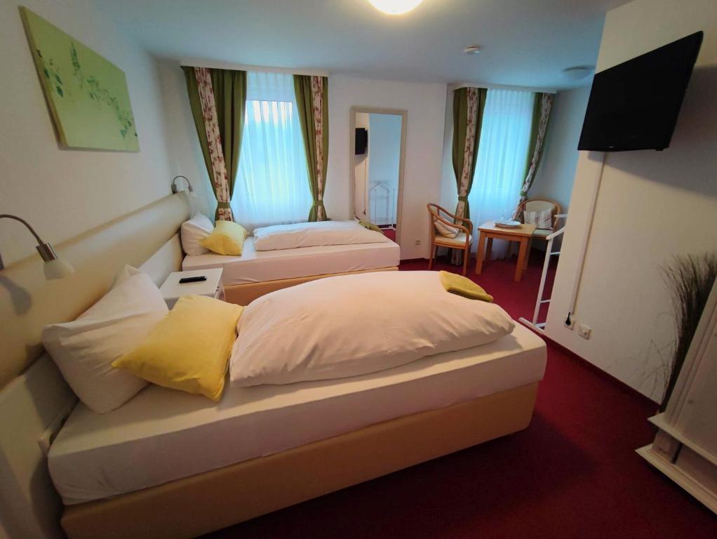 um quarto de hotel com duas camas e uma sala de jantar em Room in BB - Pension Forelle - double room em Forbach