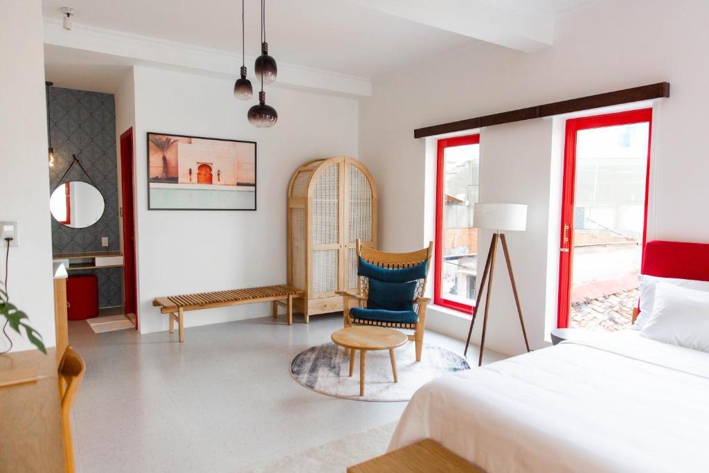1 dormitorio con 1 cama y 1 silla en Leiden Homestay&Cafe' en Ho Chi Minh