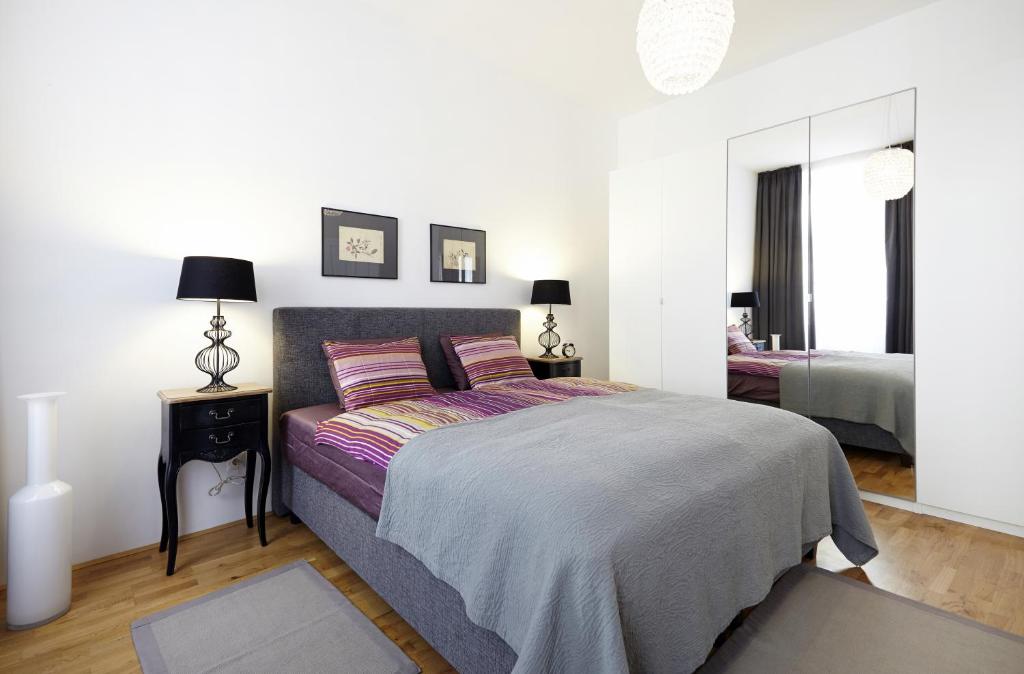 1 dormitorio con 1 cama extragrande y espejo en Apartment Theresiengasse, en Viena