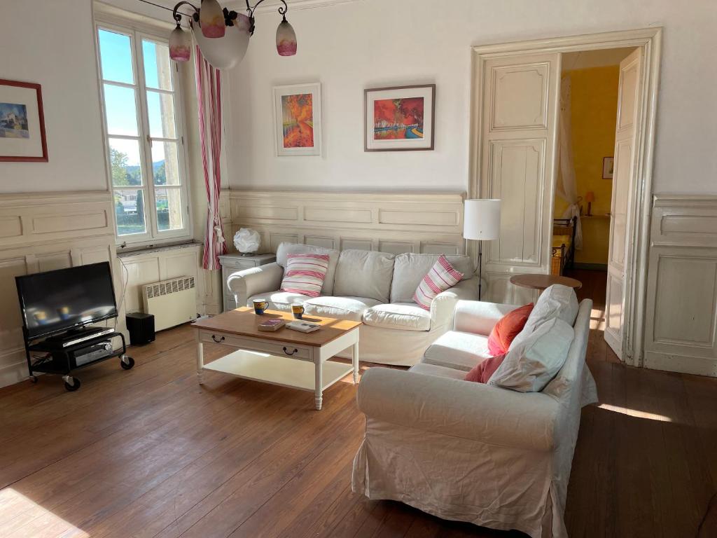 ein Wohnzimmer mit einem Sofa und einem Tisch in der Unterkunft Große Ferienwohnung am Canal du MIDI mit Dachterrrasse in Homps