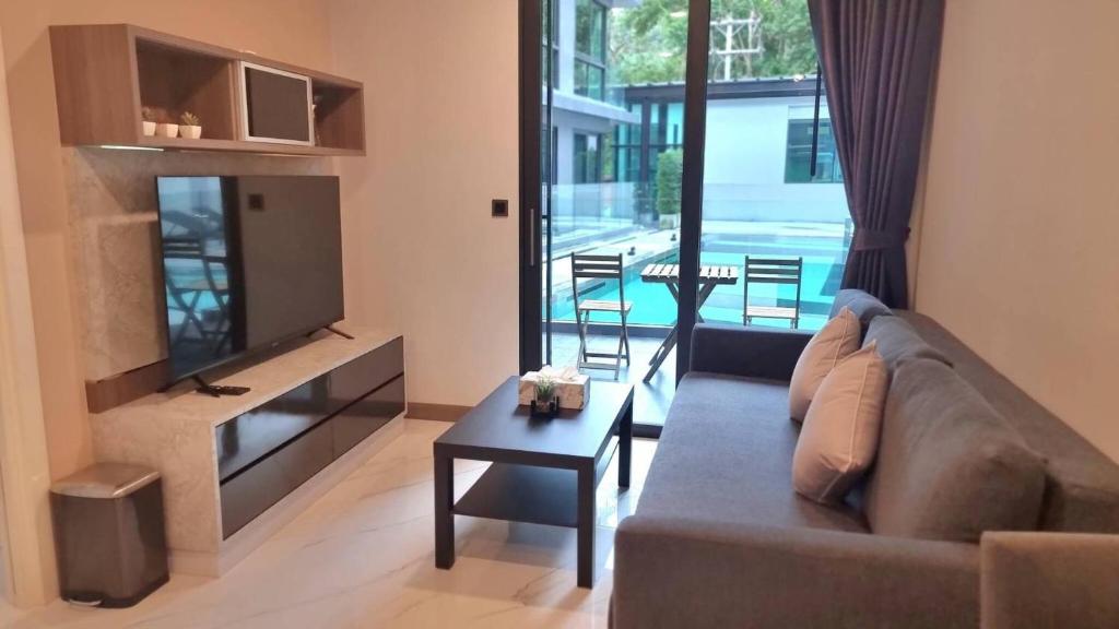 salon z kanapą, telewizorem i stołem w obiekcie B207-Hi-Ended Pool Access 1br 300m 2 Ao Nang Beach w Aonang Beach