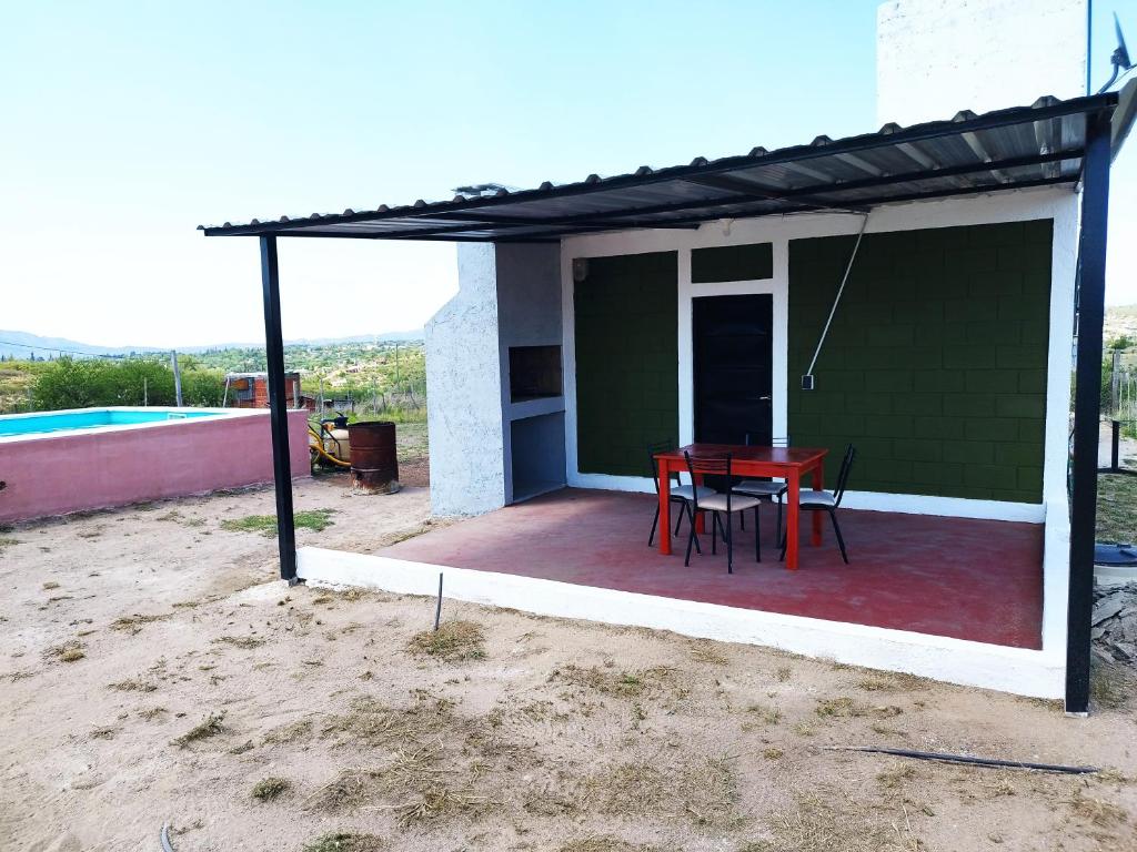 un patio con mesa y sillas en la parte superior de una casa en Cabaña Buenos Recuerdos II en Villa Santa Cruz del Lago