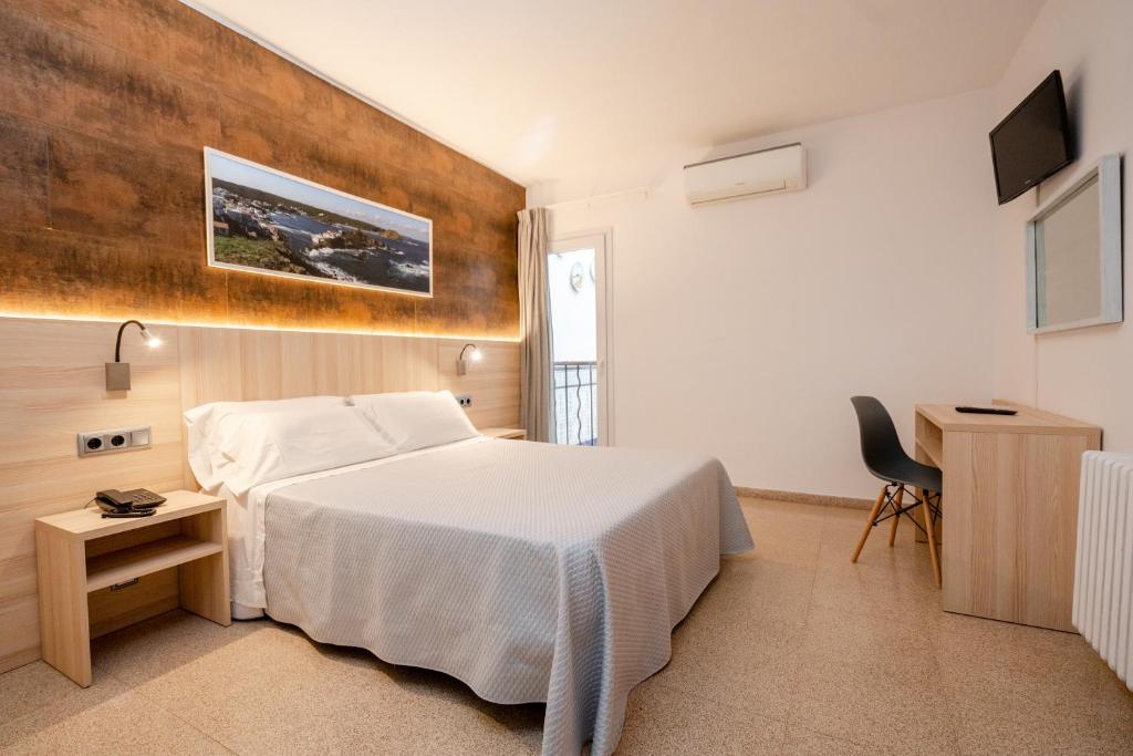 Dormitorio con cama, escritorio y TV en Eurohotel, en Mahón