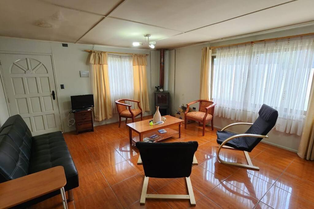 - un salon avec un canapé, des chaises et une table dans l'établissement Cabaña familiar, à Cochrane