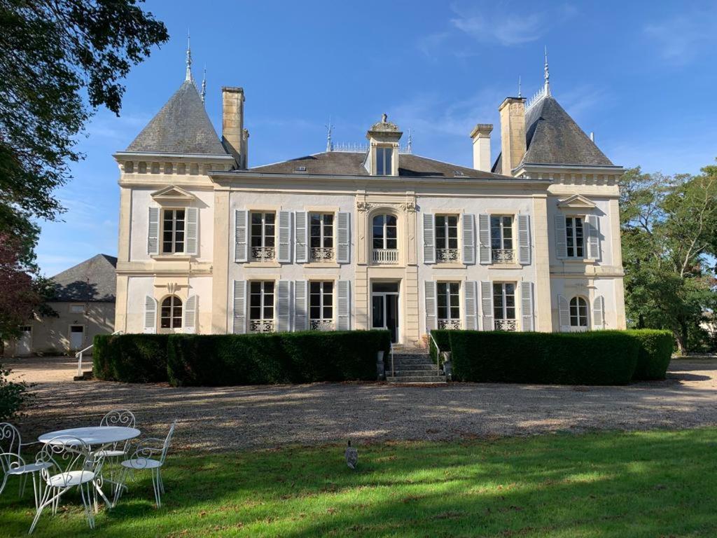 una gran casa blanca con una mesa delante en Domaine de Préfond, en Bengy-sur-Craon