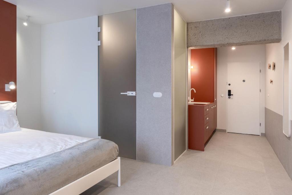 sypialnia z łóżkiem oraz łazienka z umywalką w obiekcie Odra Apartments we Wrocławiu