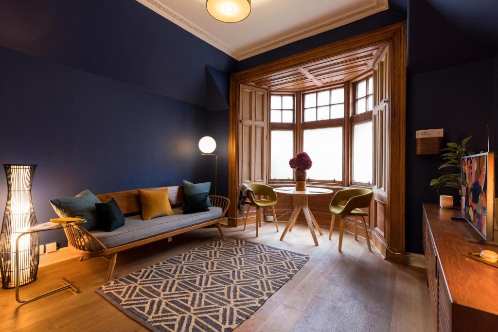 uma sala de estar com um sofá e uma mesa em ALTIDO Contemporary cottage with parking em Edimburgo