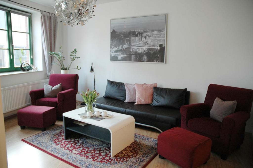 ein Wohnzimmer mit einem Sofa, 2 Stühlen und einem Tisch in der Unterkunft Sundappartement in Stralsund