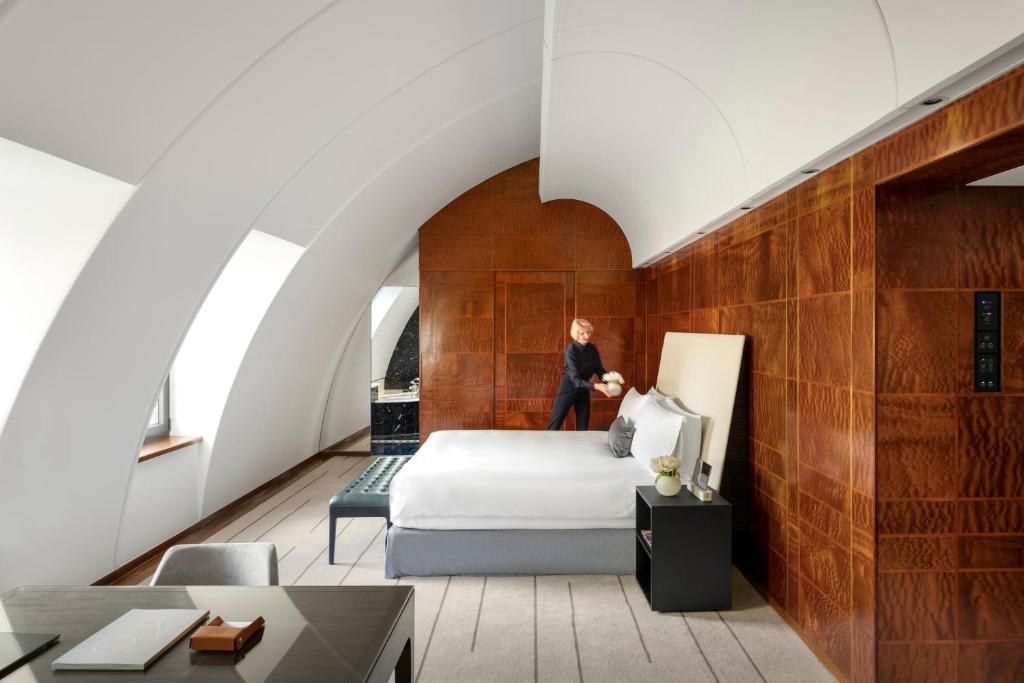 فندق COMO The Halkin  في لندن: امرأة تقف على سرير في غرفة