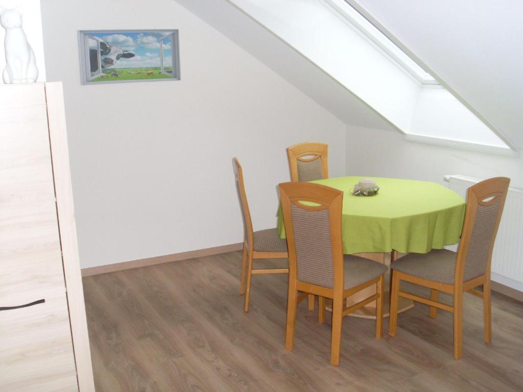 uma sala de jantar com uma mesa amarela e cadeiras em Ferienwohnung am Waldrand em Schmallenberg