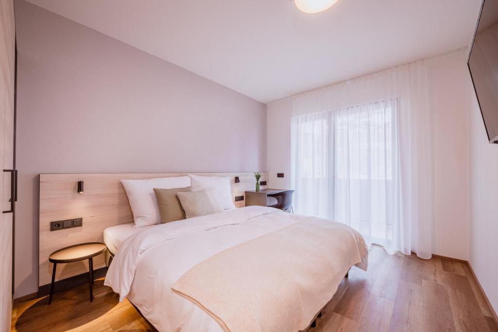 a white bedroom with a large bed and a window at Schafalm Dahoam in Schladming