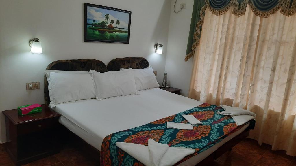 可瓦蘭的住宿－Gokulam Homestay，卧室配有一张白色大床