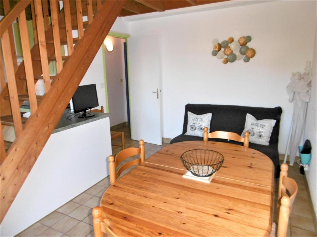 a dining room with a wooden table and chairs at Maisonnette 5 pièces 6 personnes avec WIFI - JUNA in Sarzeau